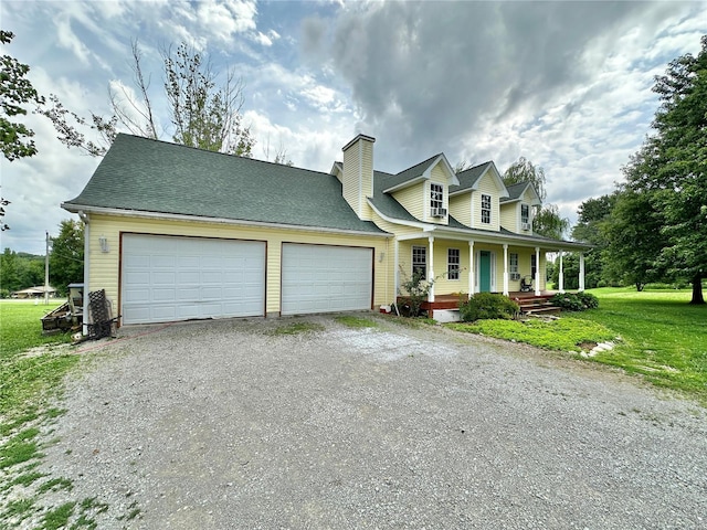 new england style home featuring a garage, covered porch, and a front lawn