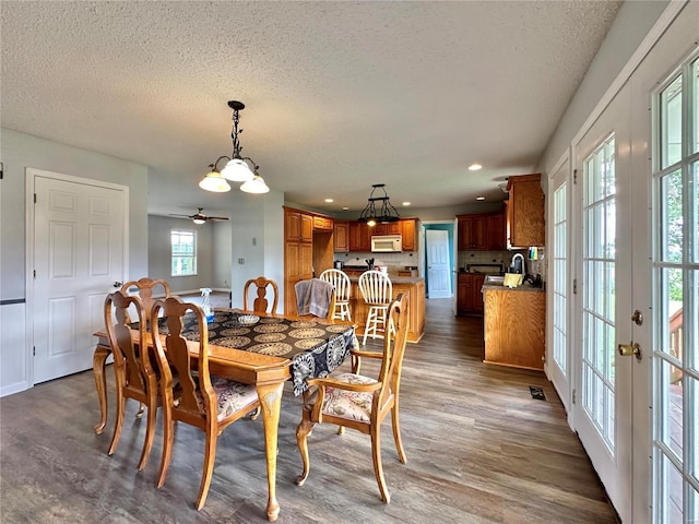 dining area featuring a textured ceiling and dark hardwood / wood-style flooring