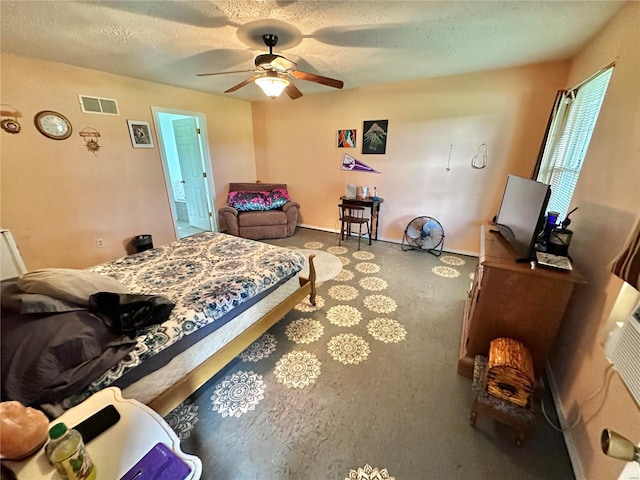 bedroom with ceiling fan, carpet floors, and a textured ceiling