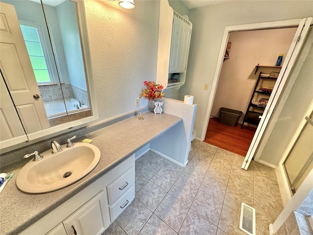 bathroom with tile patterned floors, vanity, and separate shower and tub