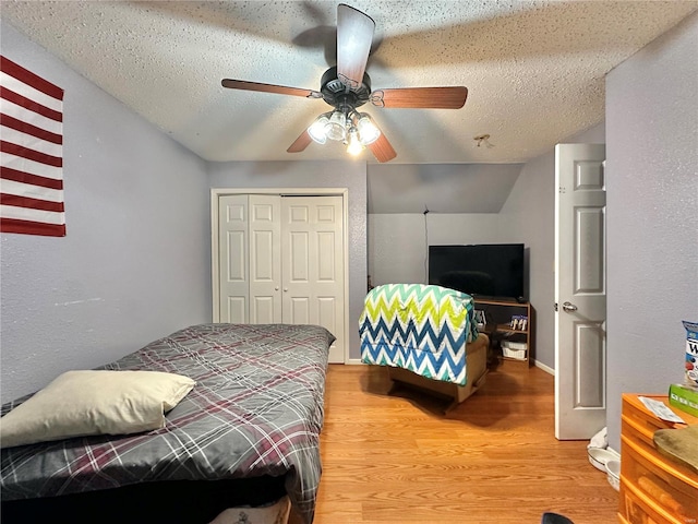 bedroom featuring wood-type flooring, ceiling fan, a textured ceiling, and a closet