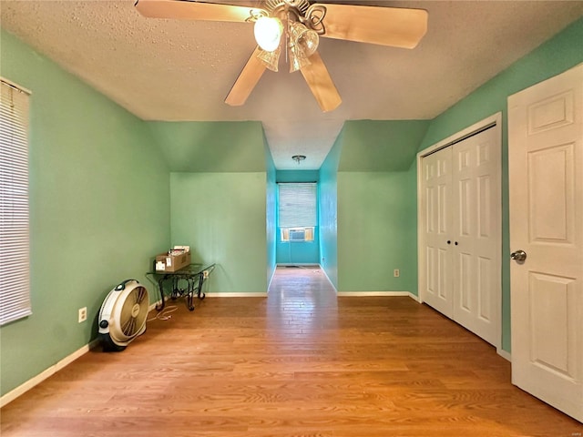 additional living space featuring a textured ceiling, ceiling fan, and light hardwood / wood-style flooring