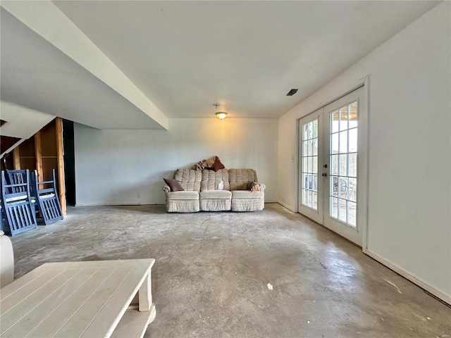 unfurnished living room featuring concrete flooring and french doors