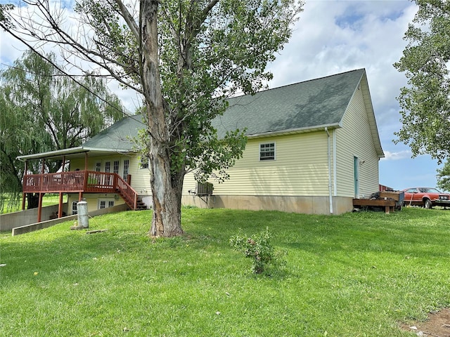 view of side of home with a yard and a deck