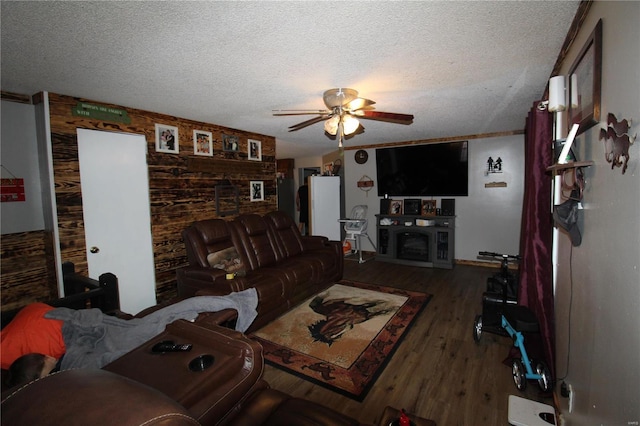 living room with ceiling fan, dark hardwood / wood-style floors, and a textured ceiling