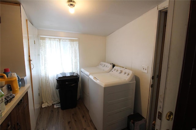 clothes washing area with washing machine and clothes dryer and dark wood-type flooring