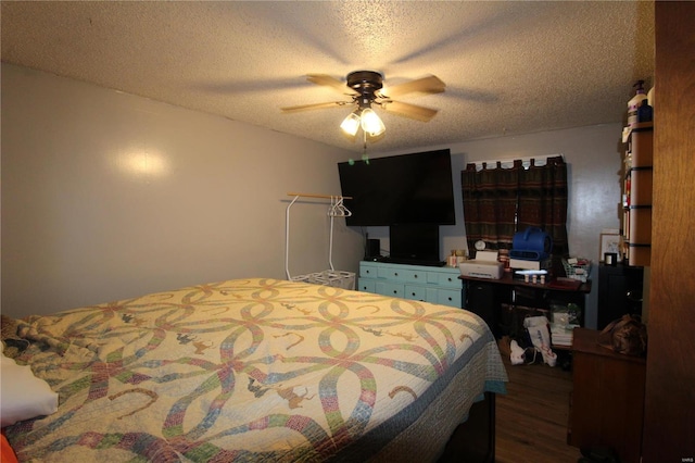 bedroom with a textured ceiling, dark wood-type flooring, and ceiling fan