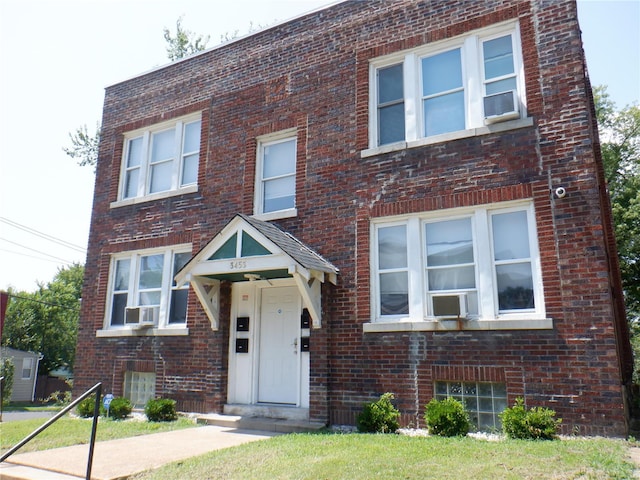 view of front of property featuring cooling unit and a front lawn