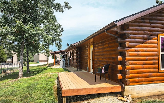 view of side of property featuring a wooden deck, a yard, and central AC unit