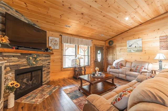 living room with wood-type flooring, a stone fireplace, vaulted ceiling, wooden ceiling, and wood walls