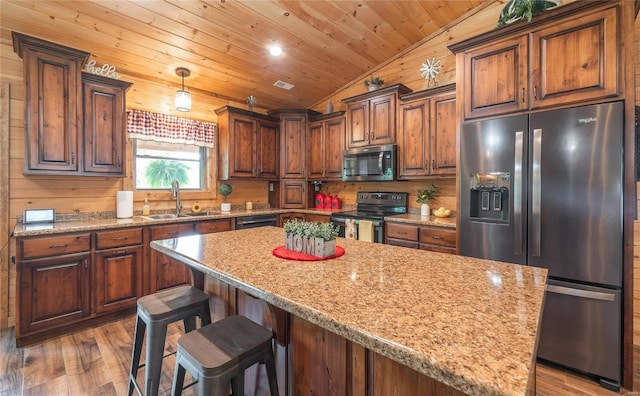 kitchen featuring sink, wood ceiling, stainless steel appliances, a kitchen island, and decorative light fixtures