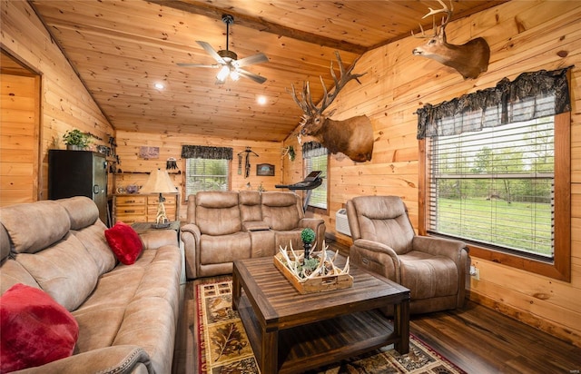 living area with vaulted ceiling, a ceiling fan, wood finished floors, and wooden walls