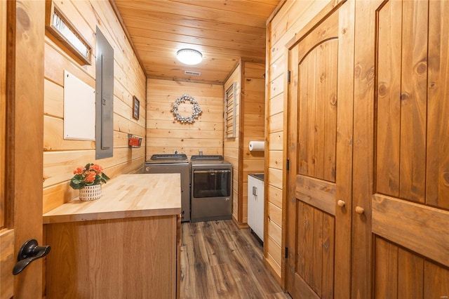 kitchen with dark wood finished floors, wood walls, washer and clothes dryer, wooden ceiling, and butcher block countertops