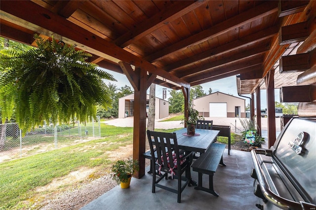 view of patio / terrace featuring an outdoor structure, outdoor dining space, and fence