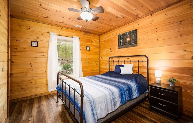 bedroom with wood ceiling, wooden walls, and dark wood-style floors