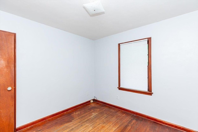 unfurnished room with dark hardwood / wood-style flooring