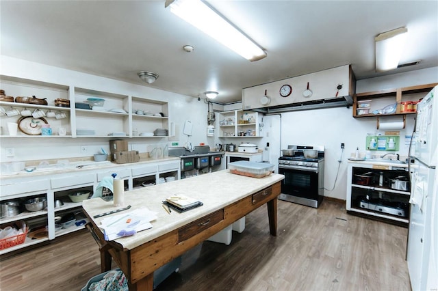 kitchen with hardwood / wood-style floors, white refrigerator, and gas stove