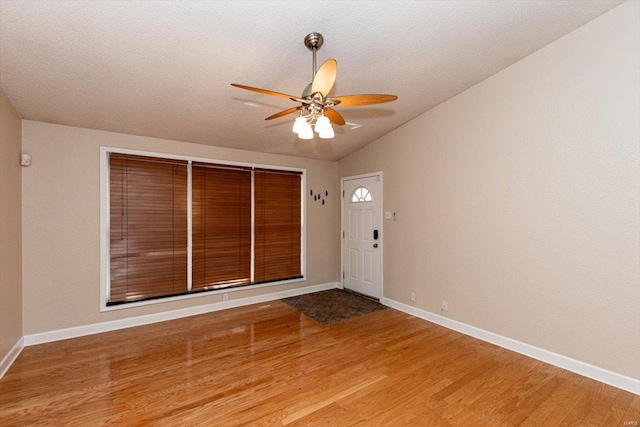 entrance foyer featuring light wood-type flooring, vaulted ceiling, ceiling fan, and a textured ceiling