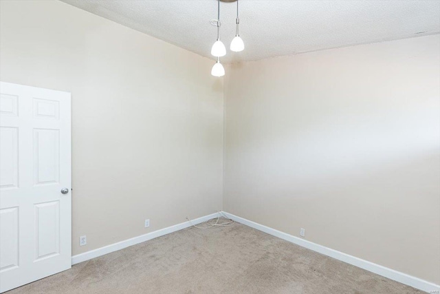 unfurnished room featuring carpet and a textured ceiling