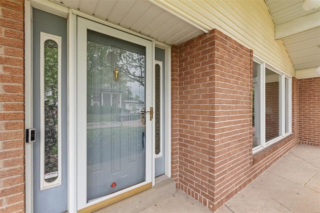 entrance to property featuring brick siding