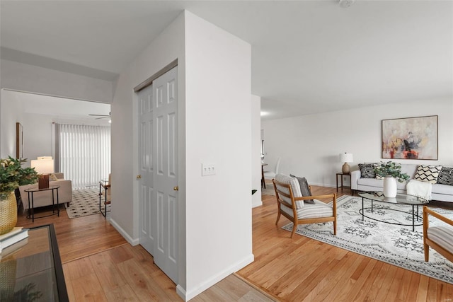 corridor with light wood-type flooring and baseboards