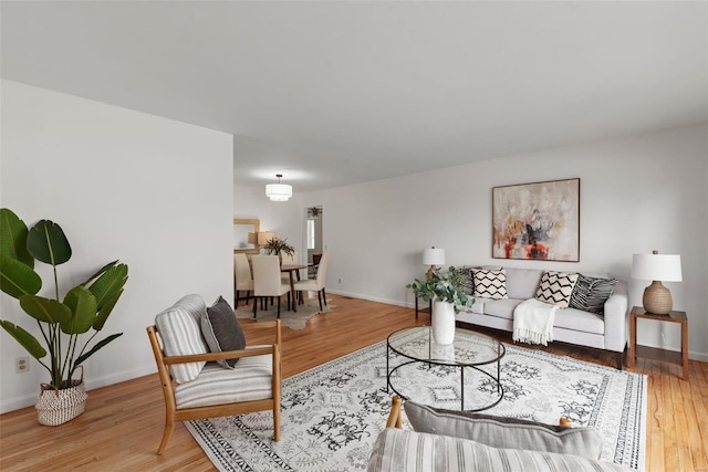 living area with baseboards and light wood finished floors