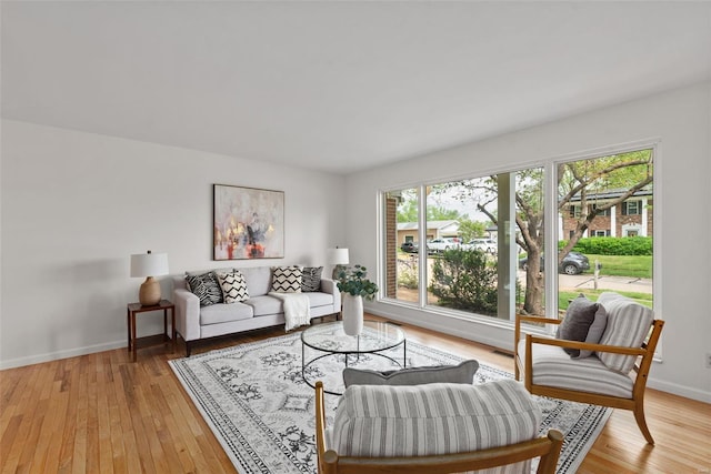 living room with baseboards and light wood finished floors