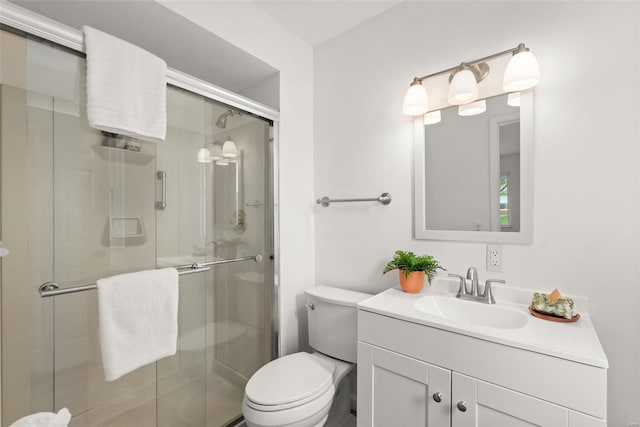 full bath featuring toilet, a stall shower, and vanity