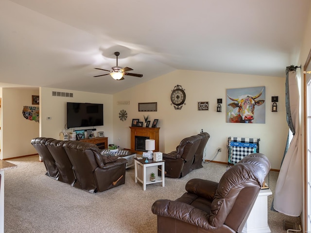 living area with carpet floors, a fireplace, lofted ceiling, visible vents, and ceiling fan