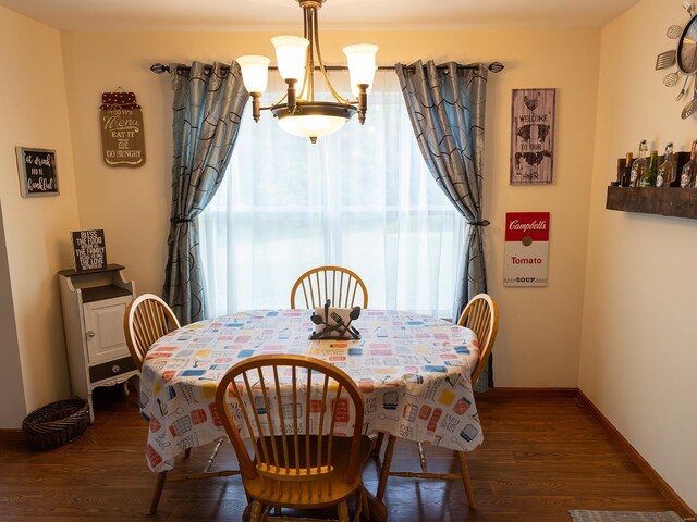 dining space with a healthy amount of sunlight, dark hardwood / wood-style floors, and a chandelier