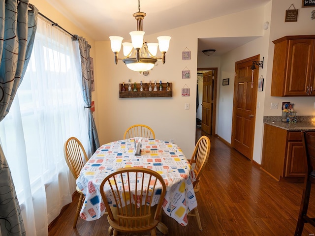 dining area featuring baseboards, dark wood-type flooring, and a notable chandelier