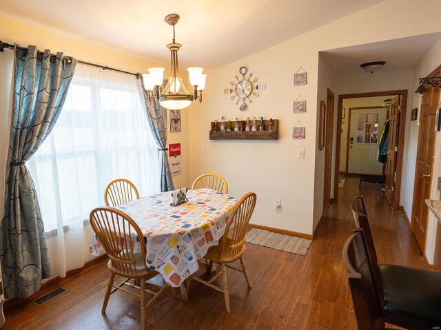 dining room featuring hardwood / wood-style flooring, lofted ceiling, and a notable chandelier