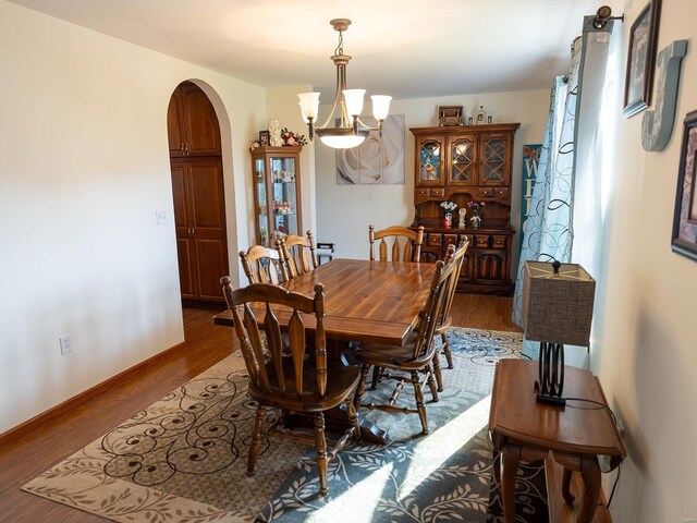 dining area featuring wood-type flooring and an inviting chandelier