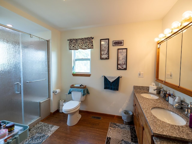 full bathroom featuring a stall shower, a sink, and wood finished floors