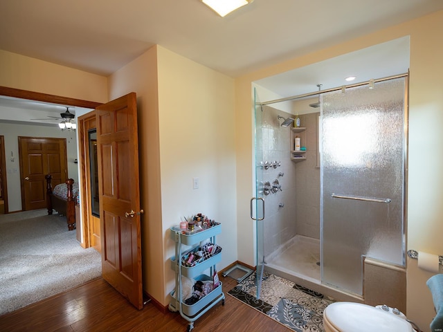 bathroom featuring a shower stall, baseboards, and wood finished floors