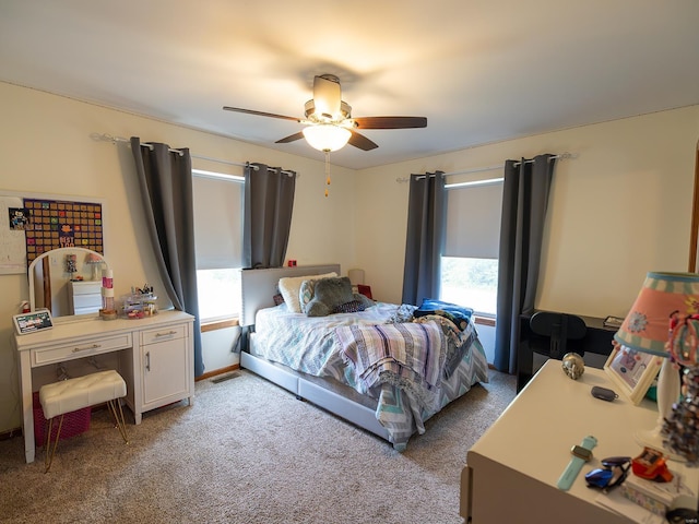 bedroom featuring ceiling fan, visible vents, and light colored carpet