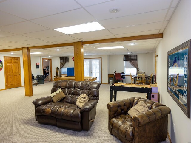 carpeted living room with a drop ceiling and french doors