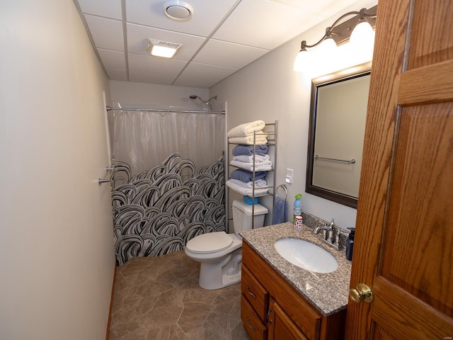 bathroom with a paneled ceiling, a shower with curtain, toilet, and vanity