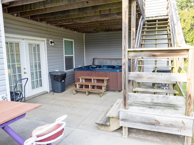 wooden deck featuring a hot tub, stairs, a patio, and french doors