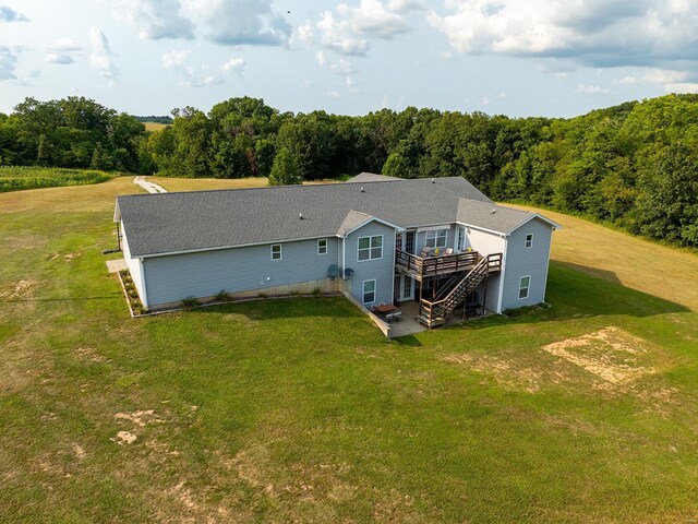 rear view of property with a wooden deck and a lawn