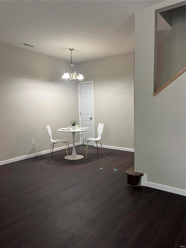 dining room featuring dark wood-type flooring and an inviting chandelier