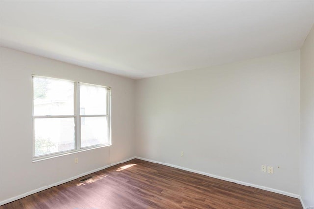 unfurnished room with dark wood-type flooring