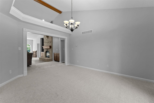 carpeted empty room featuring beamed ceiling, high vaulted ceiling, an inviting chandelier, and a brick fireplace