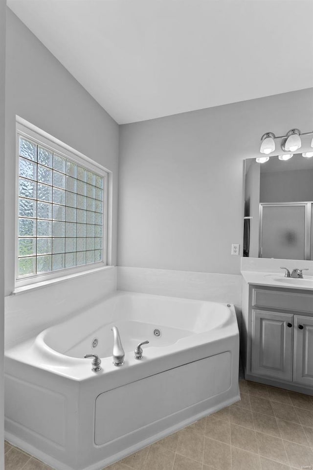 bathroom with tile patterned flooring, vanity, and separate shower and tub