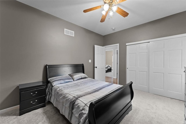 bedroom with light colored carpet, a closet, and ceiling fan