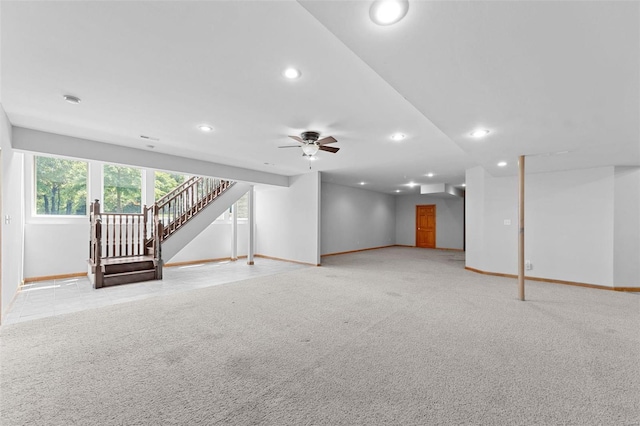 basement featuring ceiling fan and light carpet