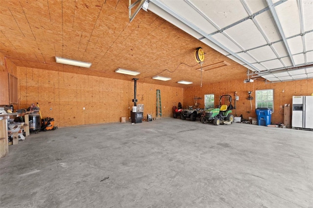 garage with a garage door opener and white fridge with ice dispenser