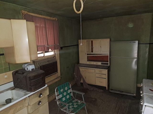 kitchen with cream cabinets, stainless steel refrigerator, and range