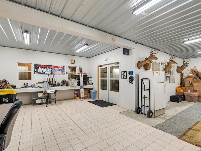 misc room with french doors, a workshop area, and light tile patterned floors