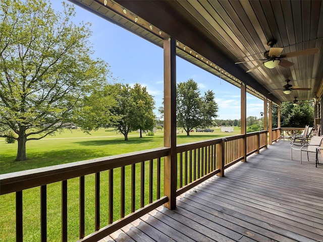 wooden deck with ceiling fan and a yard